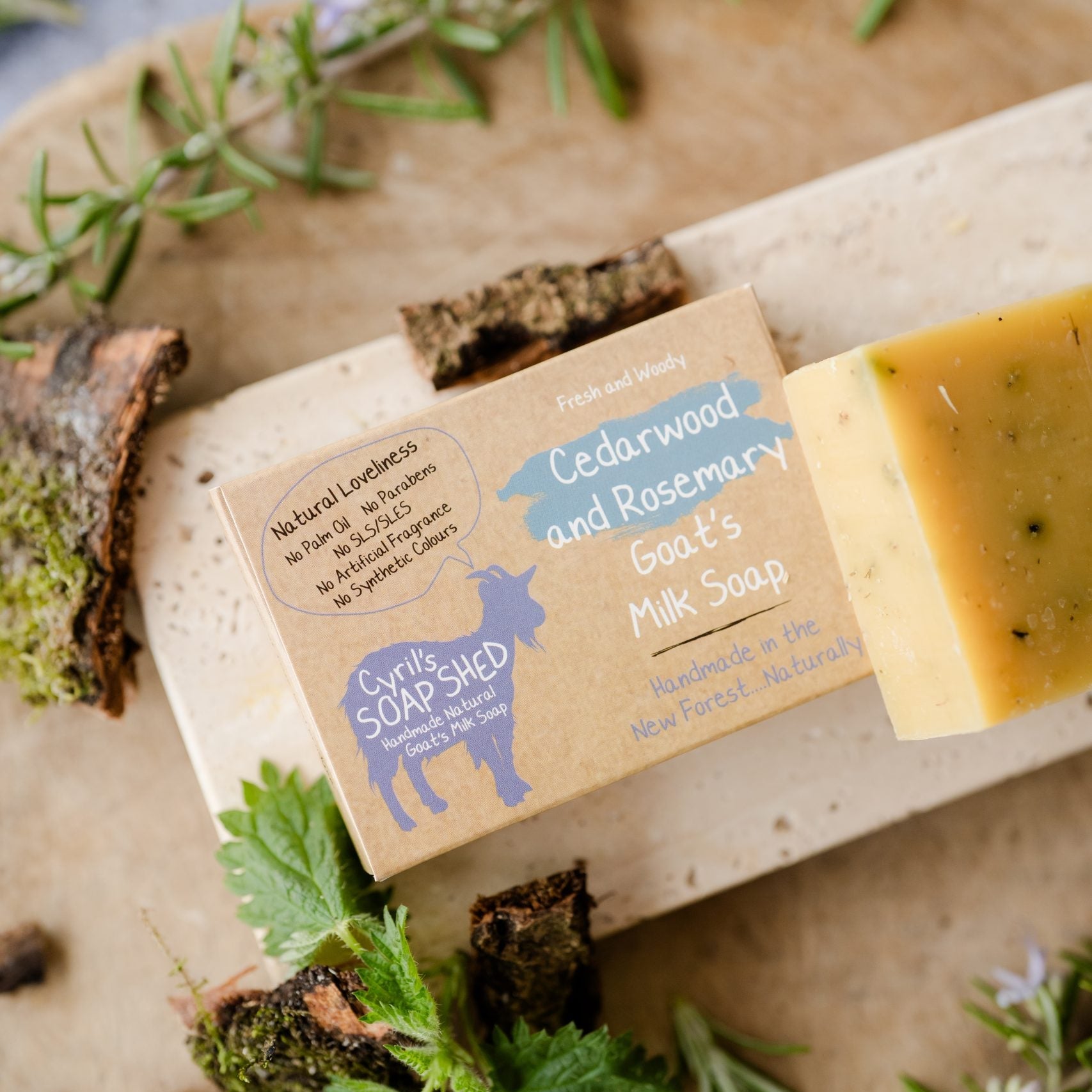 Bar of soap with a label on a wooden board surrounded by herbs