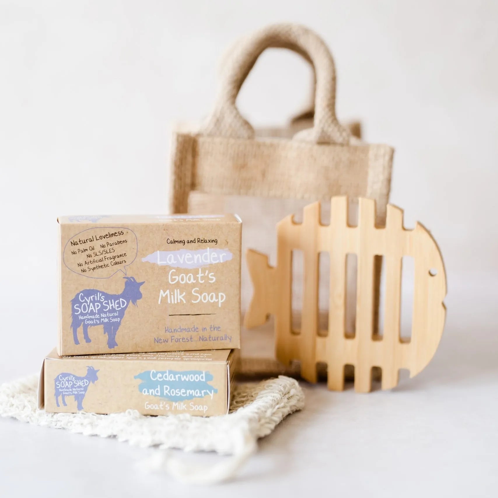 Two bars of soap with a wooden basket and decorative item on a white background